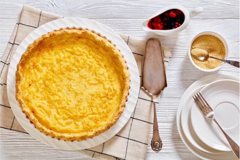 Chess pie pairs a traditional butter pie crust with a sweet, custardy filling in white baking dish, american cuisine.