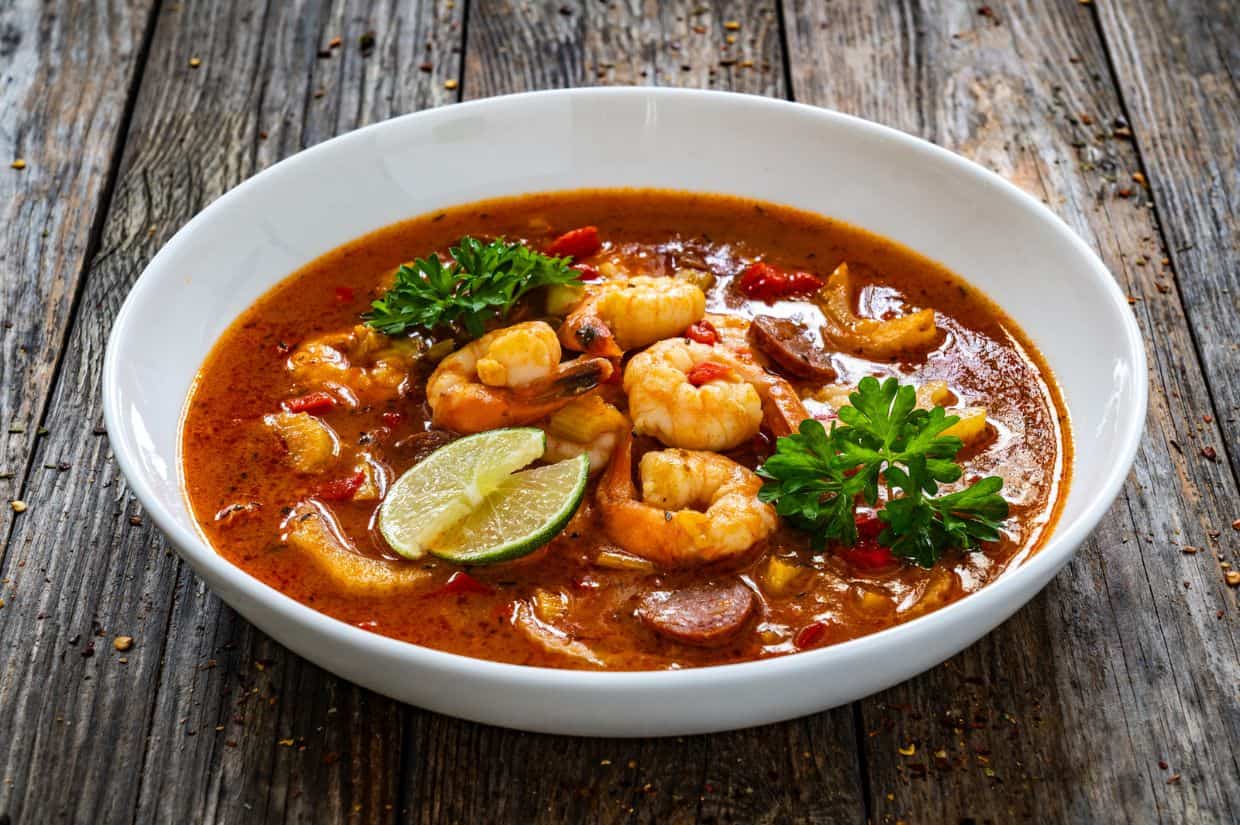 Louisiana soup gumbo with shrimp, chorizo on wooden table.