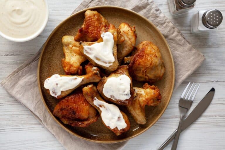 Homemade BBQ Chicken Drumsticks and Wings with Alabama White Sauce.