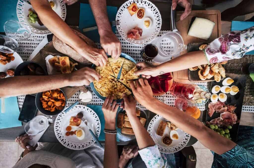 People hands taking food having dinner together.