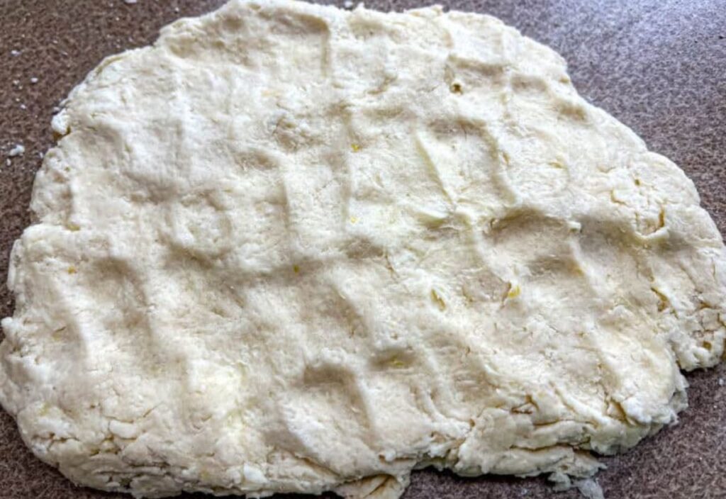 Image of the dough pressed flat on the surface.