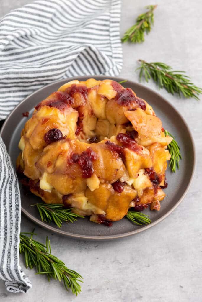 Pull-apart bread with gooey Brie and sweet cranberry sauce, served on a platter.