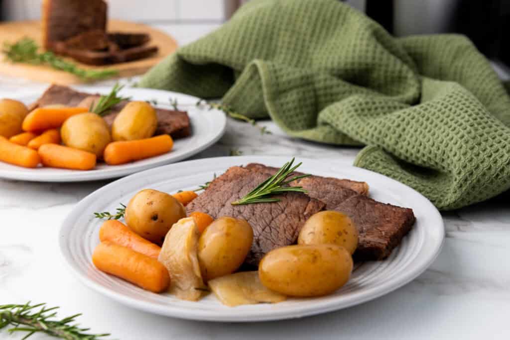 A Crockpot full of savory rump roast with vegetables, ready to be served for dinner.