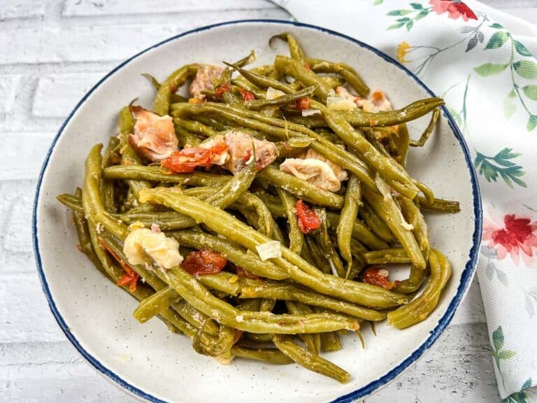 Slow Cooker Southern green beans in a white bowl with floral napkin.