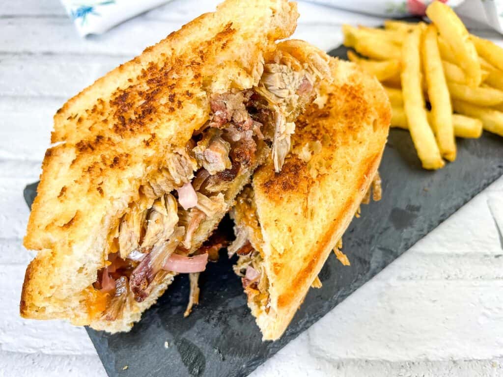 Golden-brown pulled pork grilled cheese on a plate.