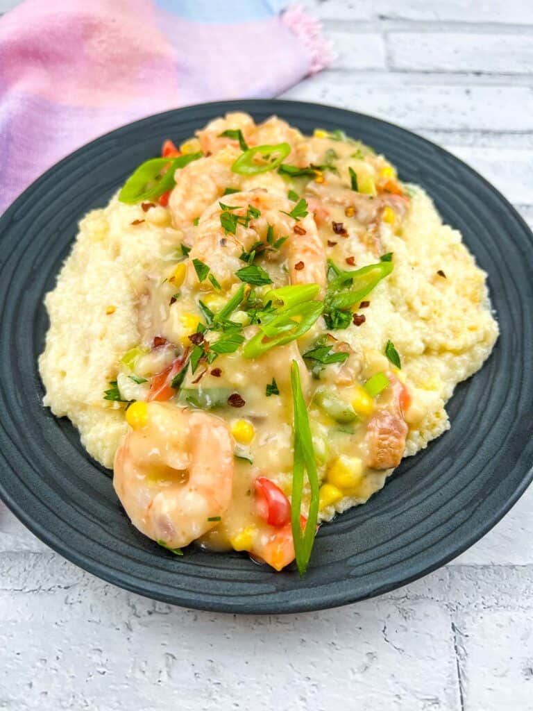 Creamy shrimp and grits casserole on a dark plate.