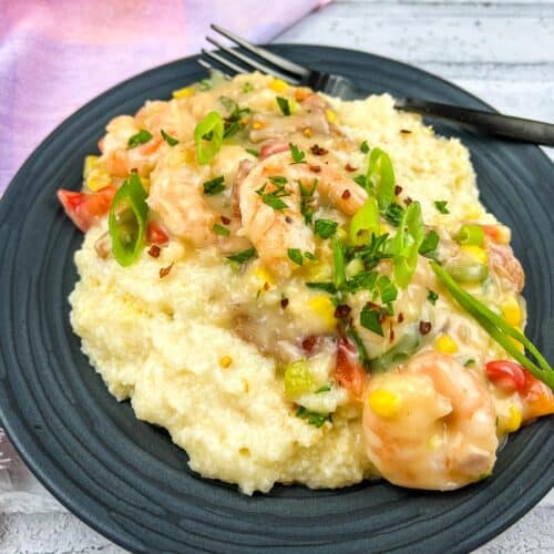 Shrimp and grits casserole garnished with green onions and herbs.