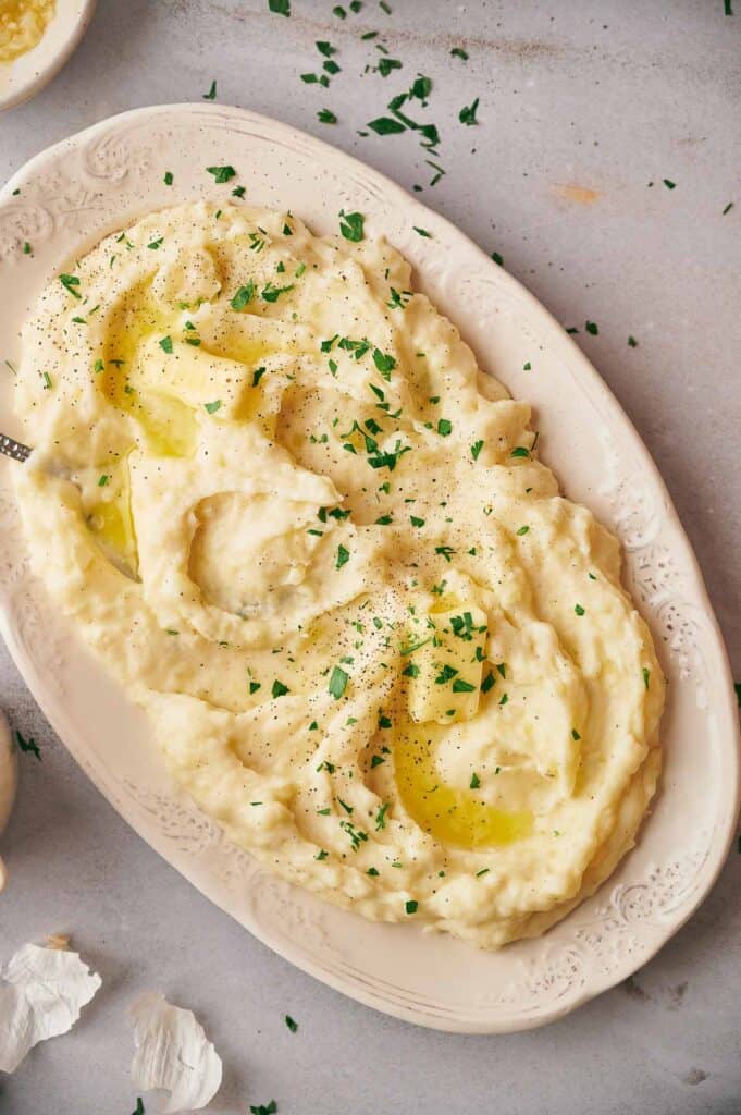 Plate of mashed potatoes garnished with fresh parsley.