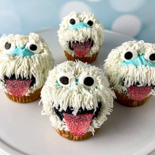 Snowman-themed cupcakes with fluffy white frosting and candy eyes.