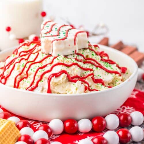 Festive Christmas tree cake dip topped with red icing drizzle.