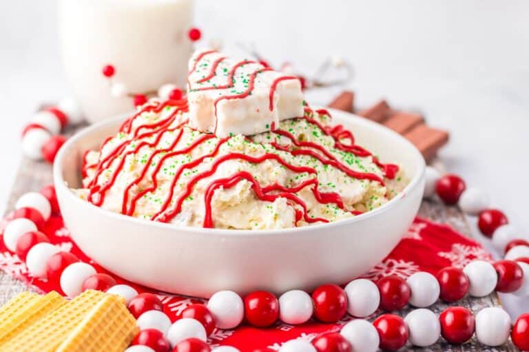 Festive Christmas tree cake dip topped with red icing drizzle.