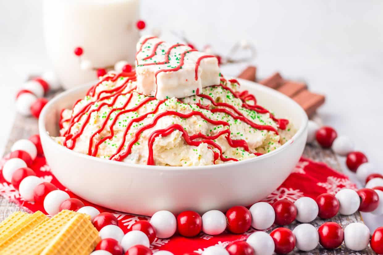 Festive Christmas tree cake dip topped with red icing drizzle.