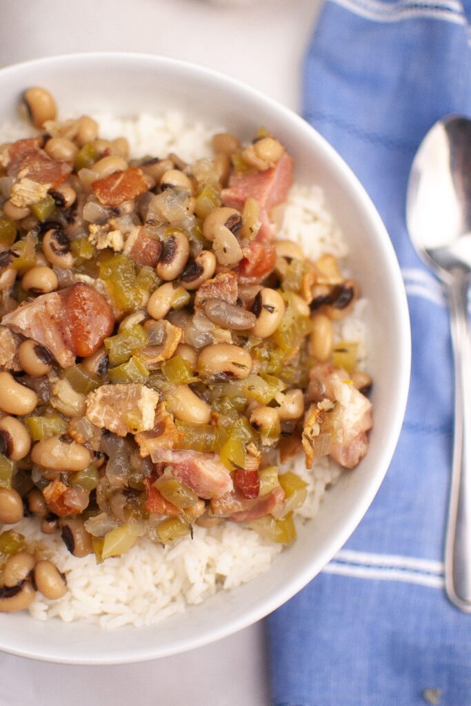 Close-up of Hoppin’ John with black-eyed peas, diced ham, and green peppers on rice.