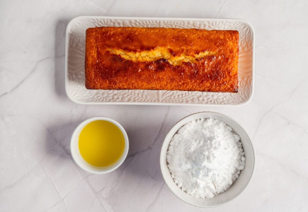 Baked cake with powdered sugar and lime juice on the side.