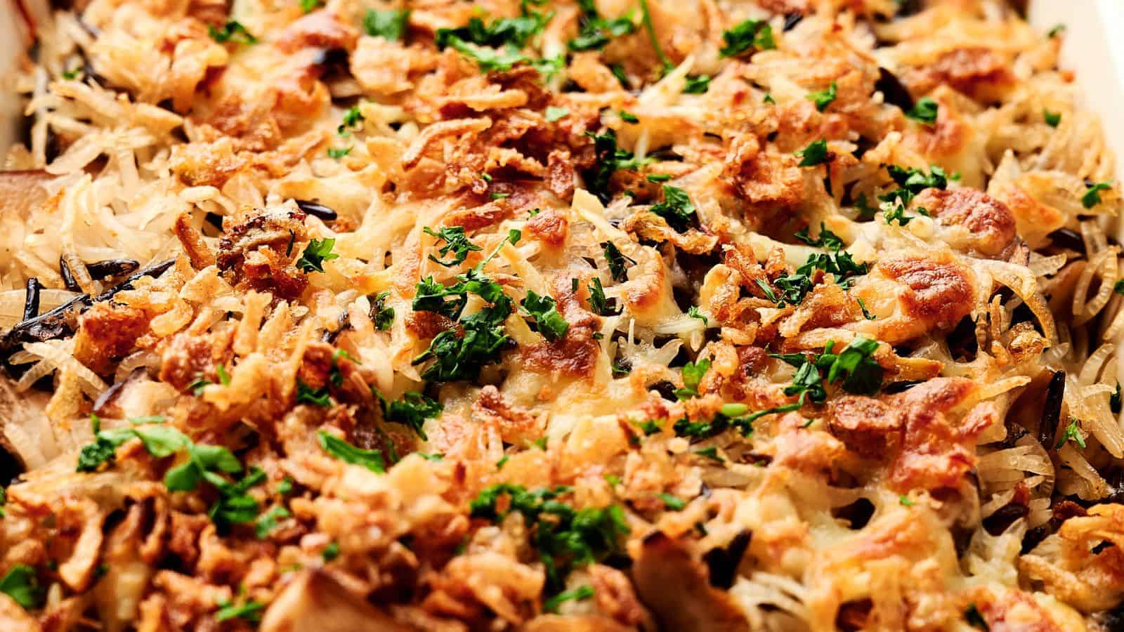 Close-up of an air fryer mushroom casserole topped with crispy, browned ingredients and garnished with chopped green herbs.