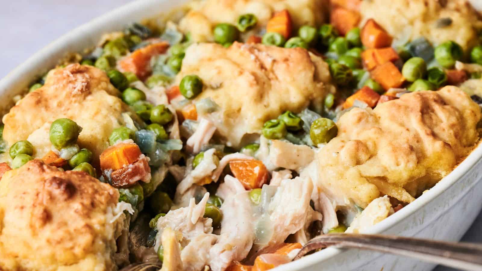 Air Fryer Chicken and Dumpling Casserole on a white dish with a spoon dishing it up.