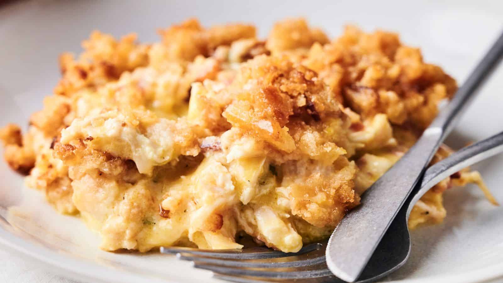 A close-up of air fryer crack chicken casserole served on a plate with a fork and knife ready for serving.