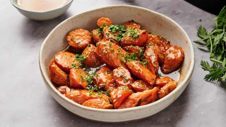 Air fryer glazed carrots in a bowl with parsley.