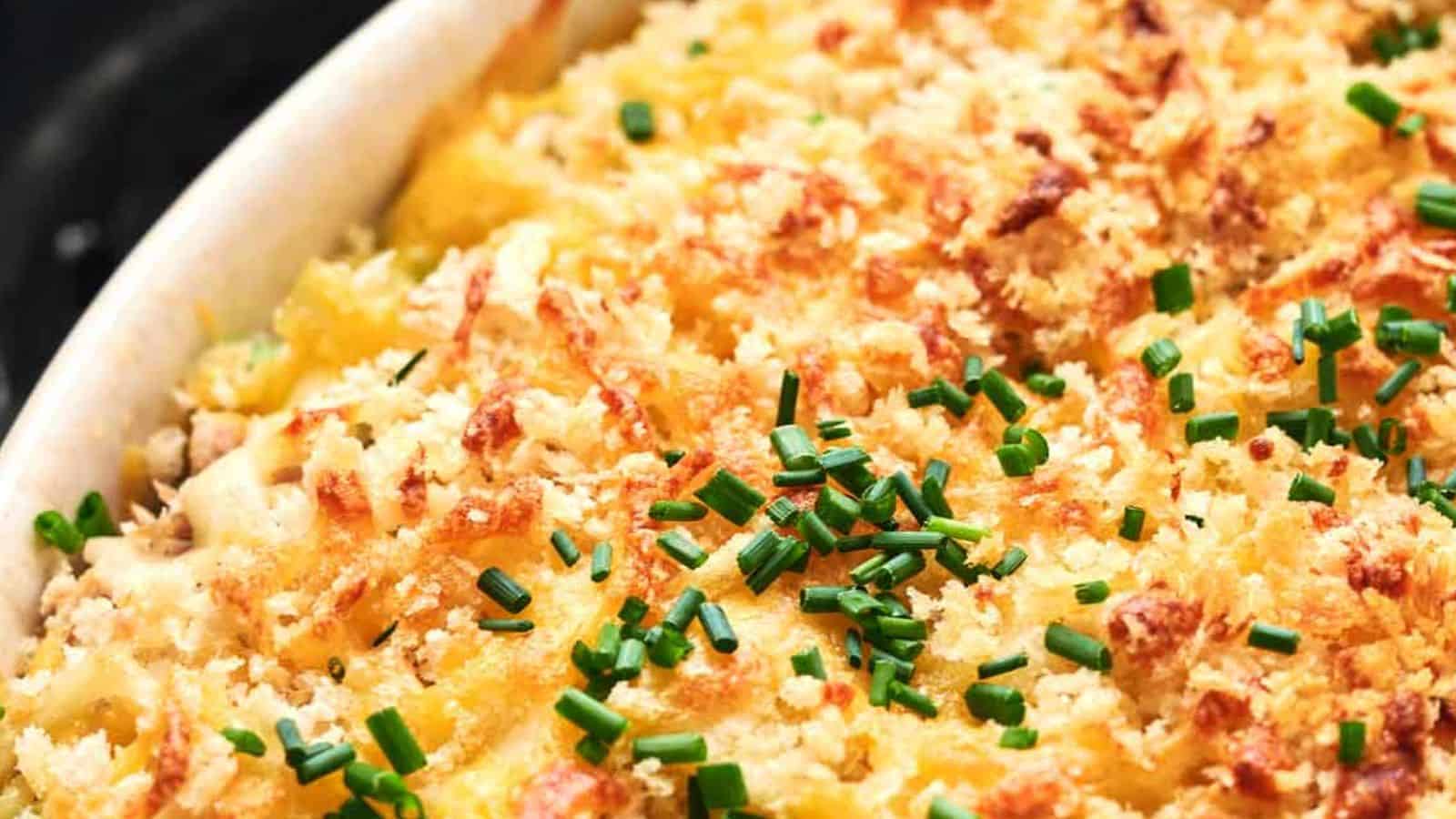 A close-up of a baked dish topped with golden bread crumbs and chopped chives.