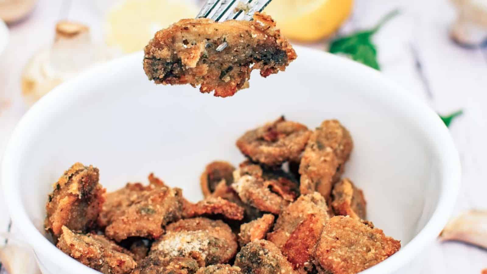 Breaded Mushrooms in a white bowl with a fork.