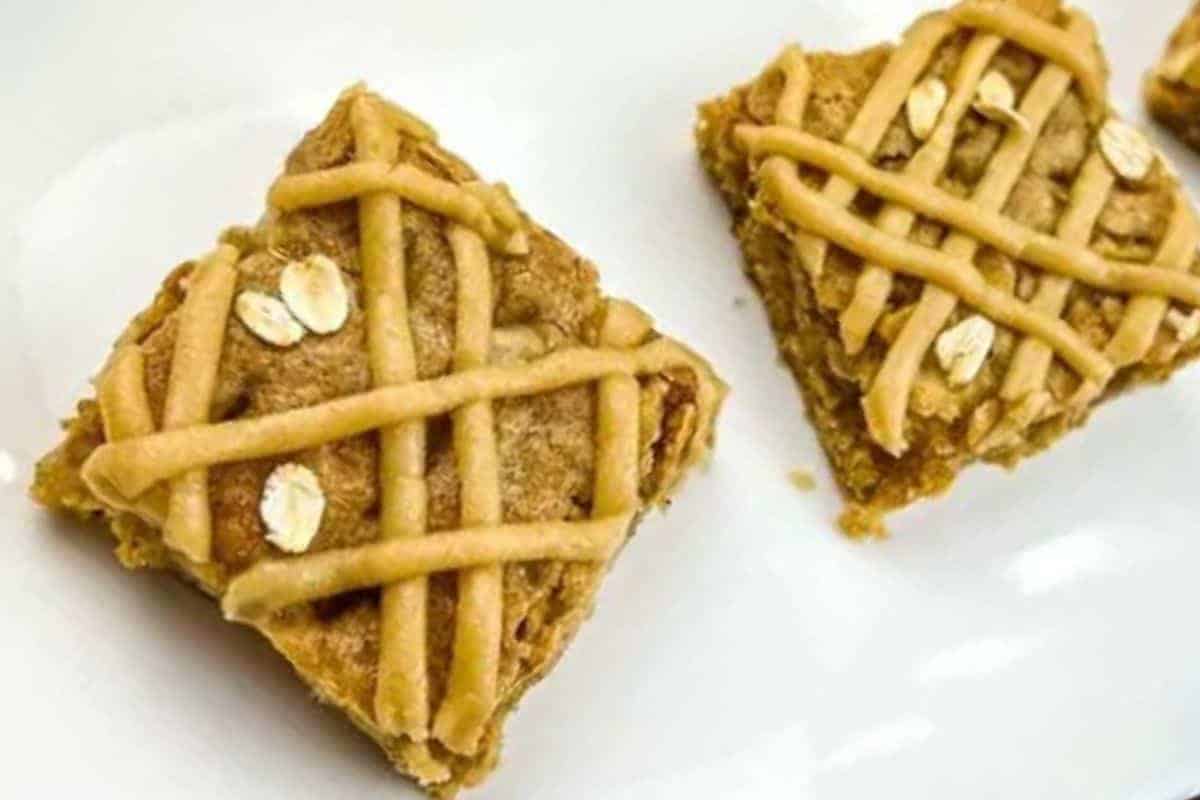 Two brown butter apple blondies were placed on a white surface.