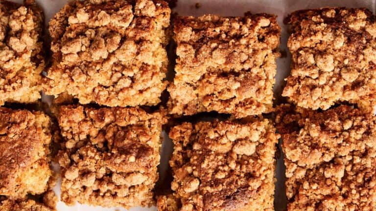 Close-up of eight square pieces of crumb cake with a textured, crumbly topping.