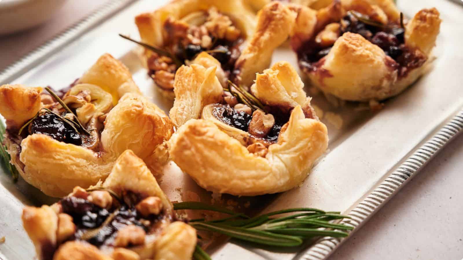 A tray of cranberry brie bites with walnut topping.