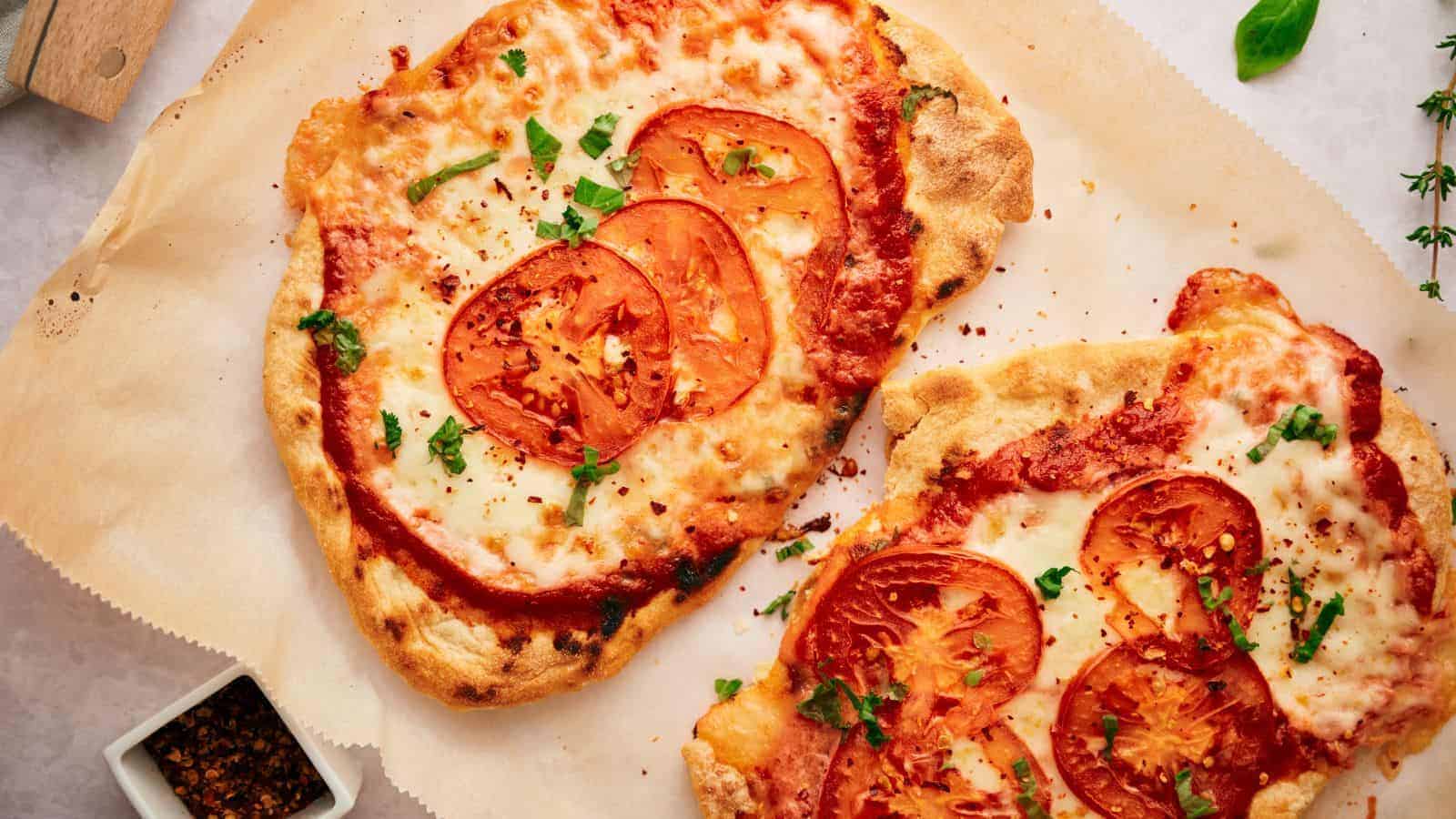 Two slices of pizza with tomatoes and herbs.