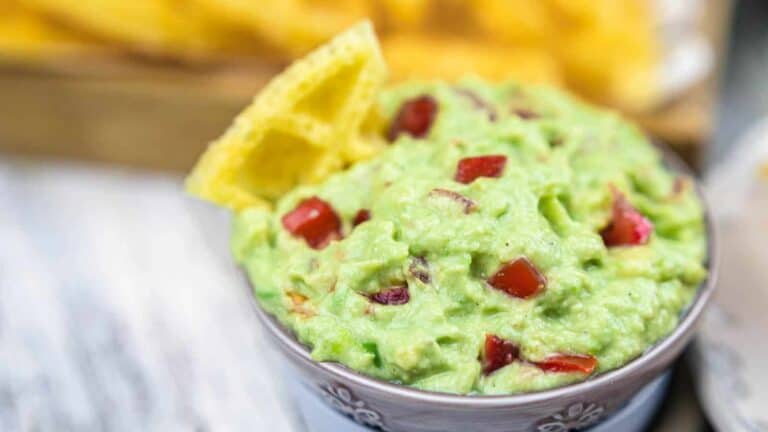 Guacamole Dip with Sour Cream in a bowl with chips.