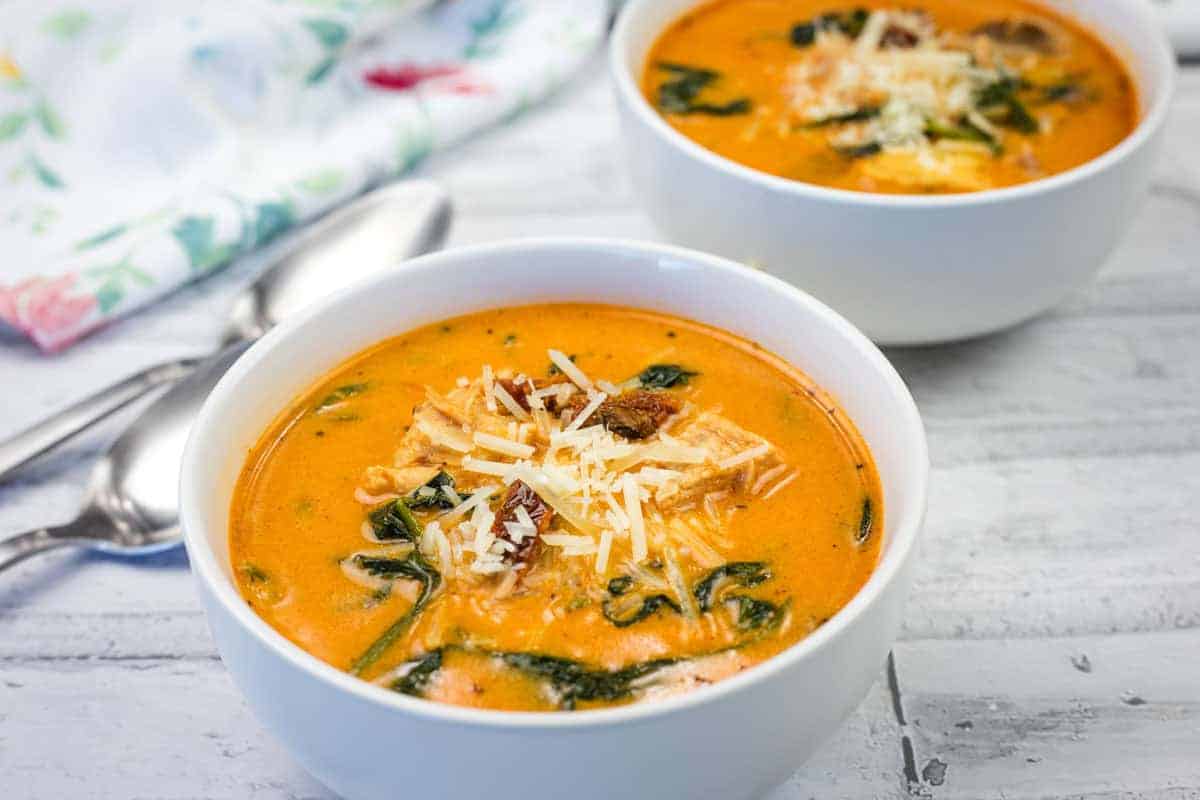 Two bowls of Marry Me chicken soup on a wooden table.