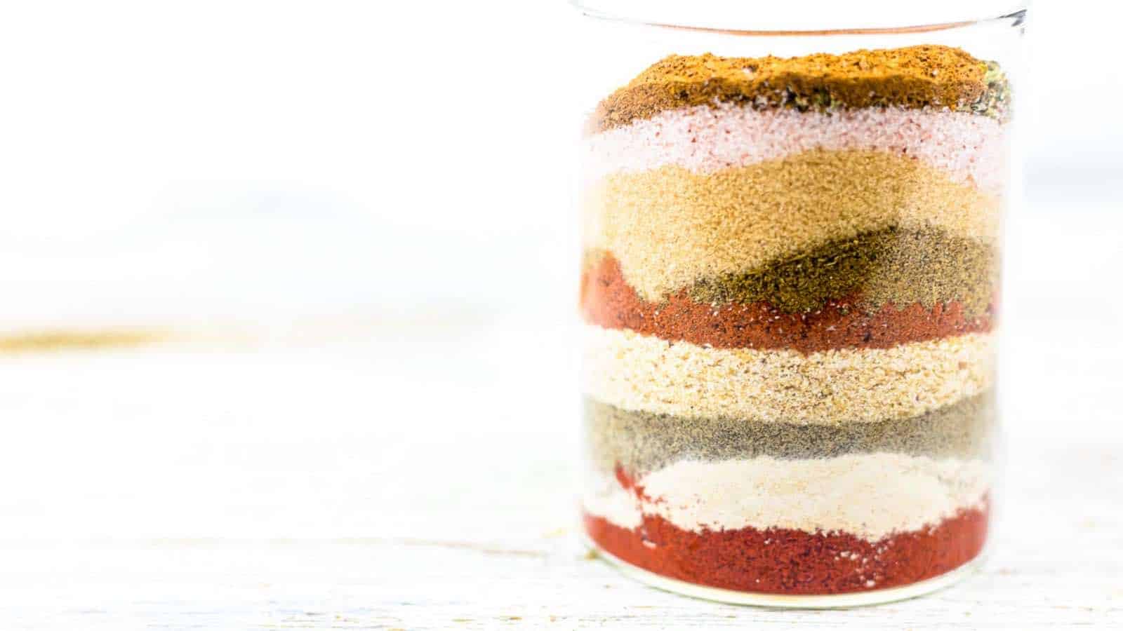 Spices in a glass jar on a wooden table.