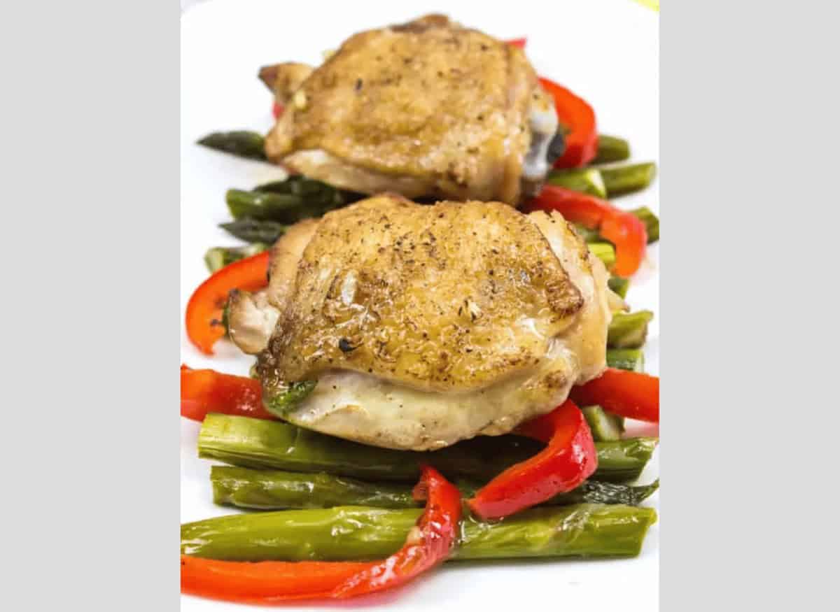 Garlic Chicken Skillet with peppers and asparagus on a white plate.