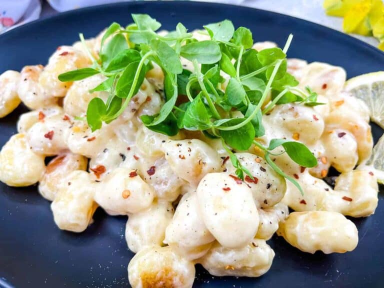 Gnocchi in Lemon-Parmesan Sauce on a black plate.