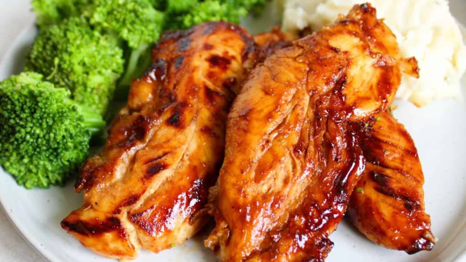 A plate with honey chicken tenders, broccoli florets, and mashed potatoes.