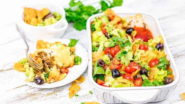 Taco casserole with fresh vegetables in a rectangular dish, a plate, and a circular dish.