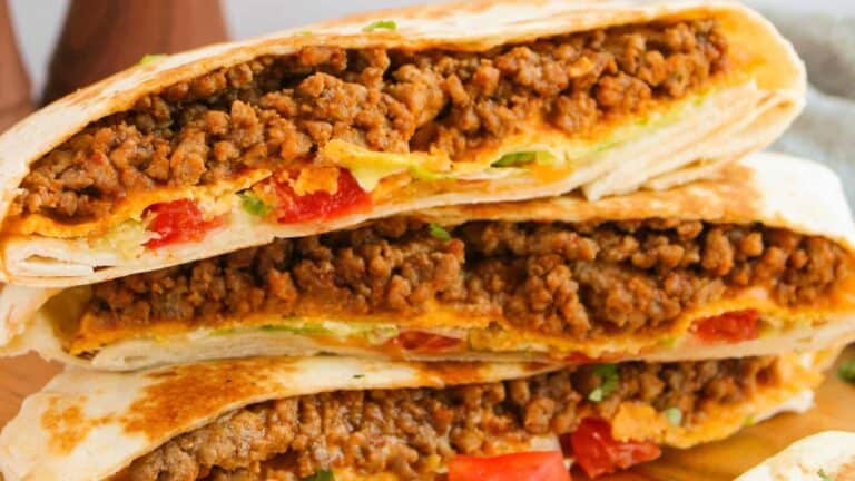 Crunchwrap Supreme filled with seasoned ground meat, diced tomatoes, and melted cheese.