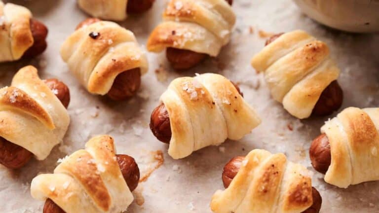 Pigs in a Blanket on a baking sheet lined with parchment paper.