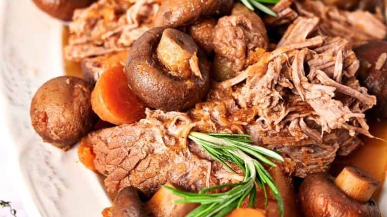 Slow Cooker Pot Roast with mushrooms on a white plate.