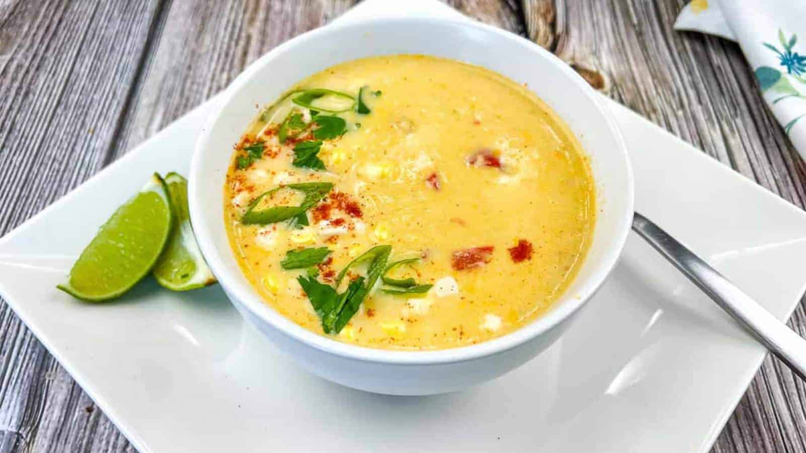 Mexican street style corn soup in a white bowl on a white plate.