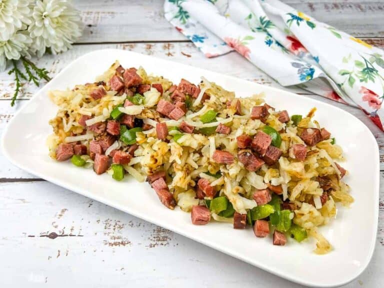 A white rectangular plate with Montreal smoked meat hash on it.