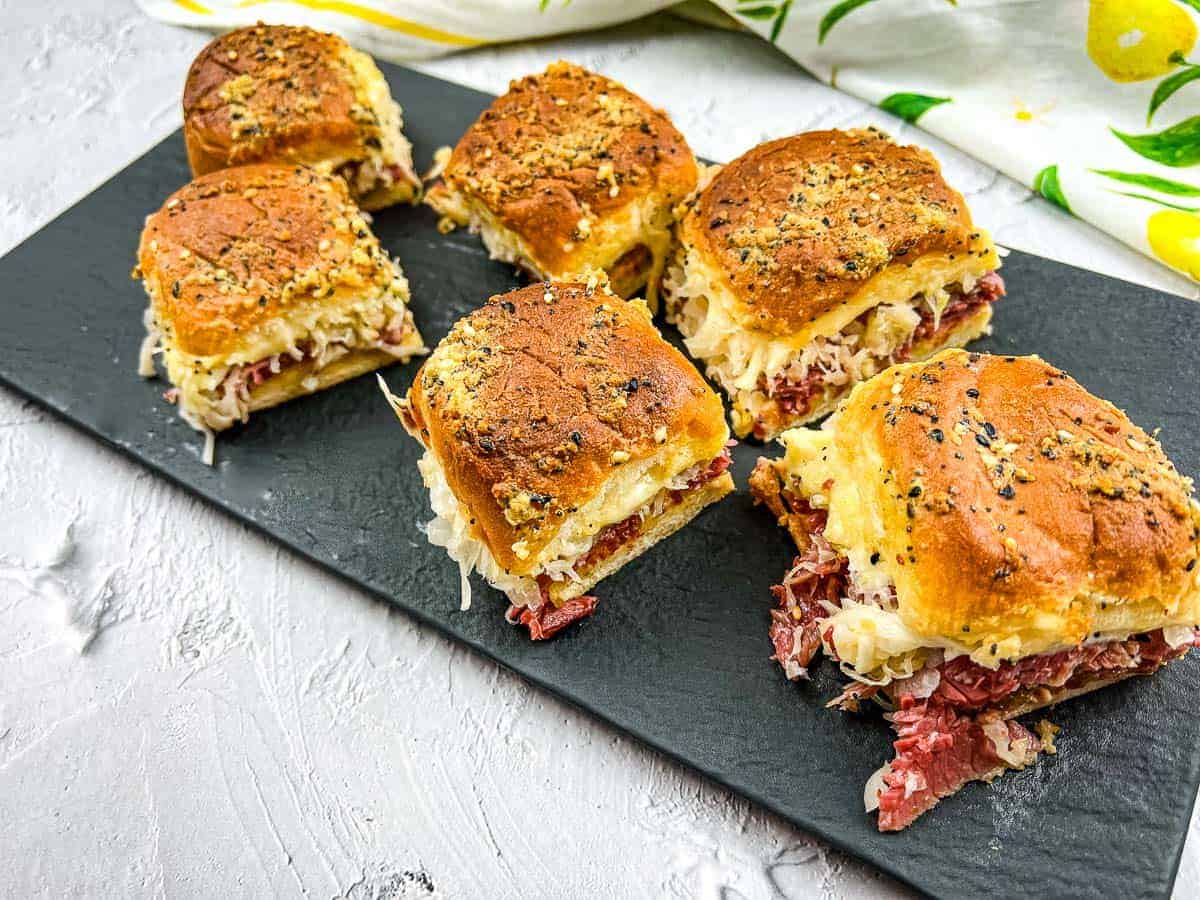 Reuben sliders on a slate board.