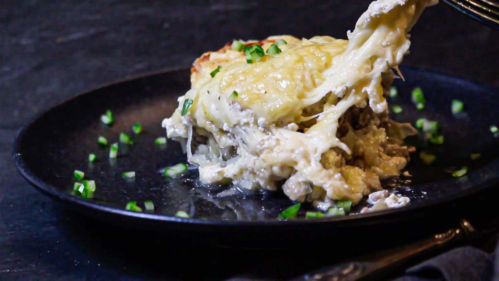 Eating a casserole on a plate with fork.