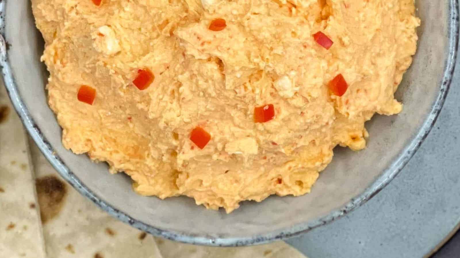 Spicy Greek feta dip in a bowl with pita bread by the side.