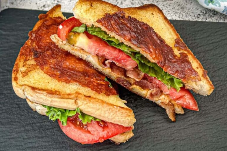 Two Texas BLT on a black slate plate.