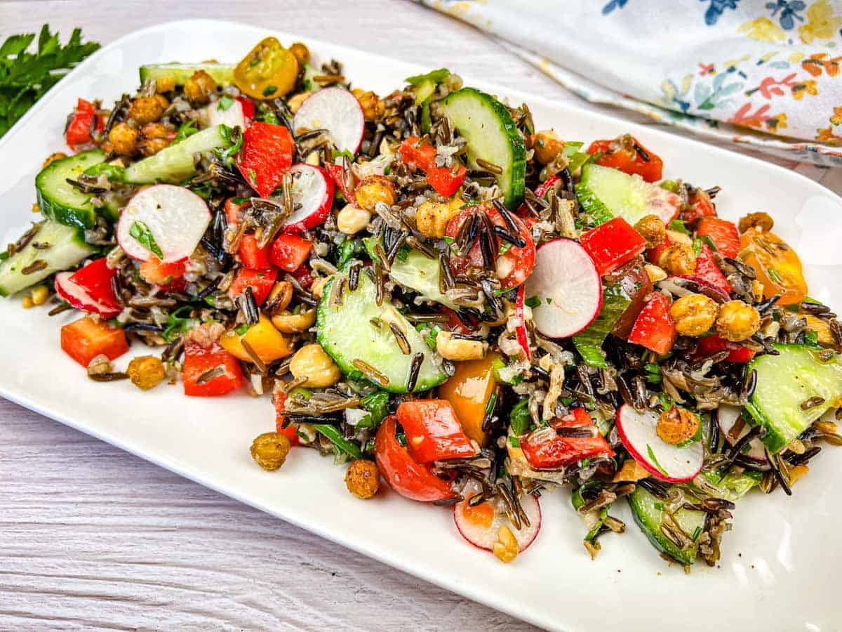 Wild rice salad served on a white rectangular plate.