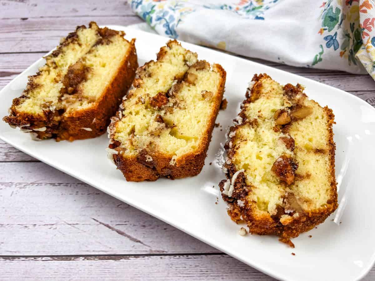 Three slices of apple fritter bread on a white plate.