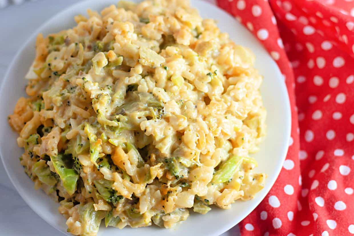 A close-up of a plate filled with cheesy broccoli rice casserole, featuring tender broccoli, creamy cheese sauce, and rice.