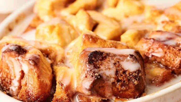 Close-up of a dish of warm cinnamon rolls topped with white glaze.