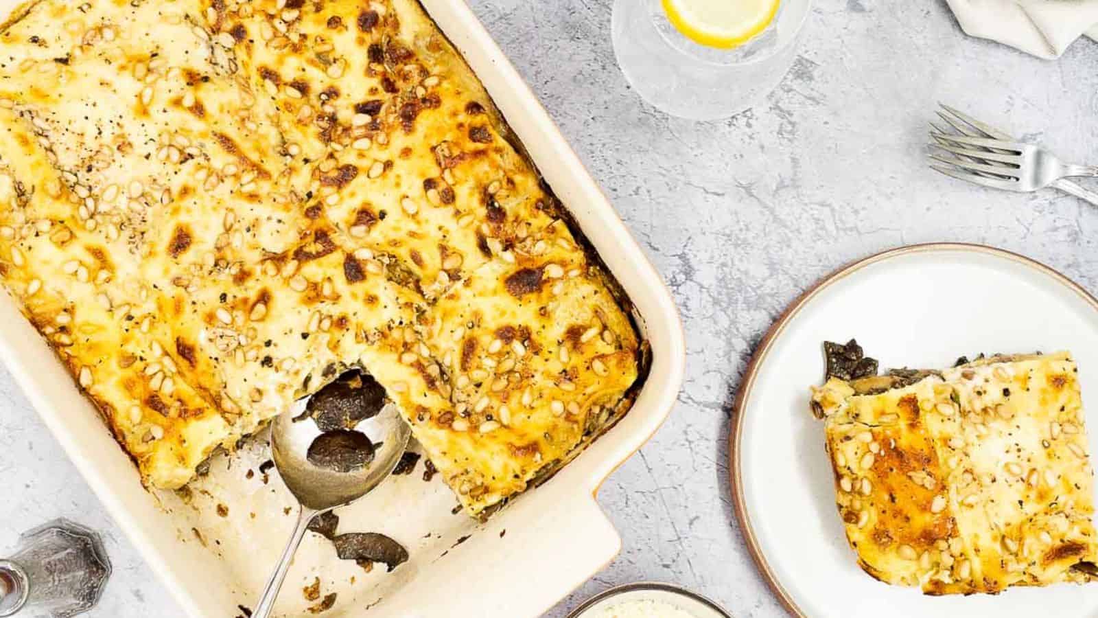 A baked Four Cheese Lasagna in a casserole dish with a serving on a plate.