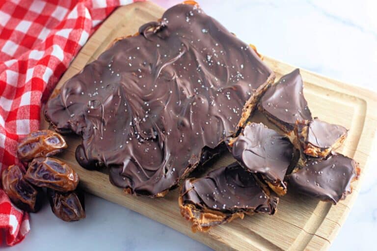 A close-up of a homemade chocolate bark topped with smooth melted dark chocolate, sprinkled with sea salt.